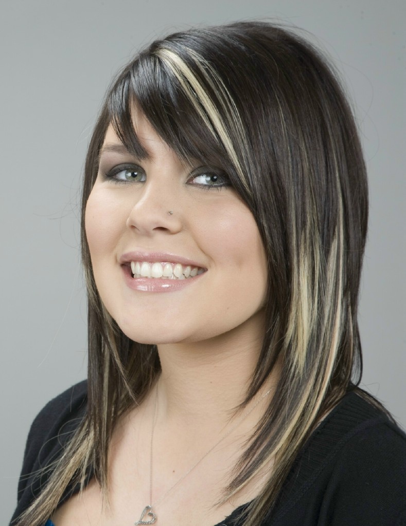 A salon model with dark shoulder-length hair striped with bold blonde chunky highlights