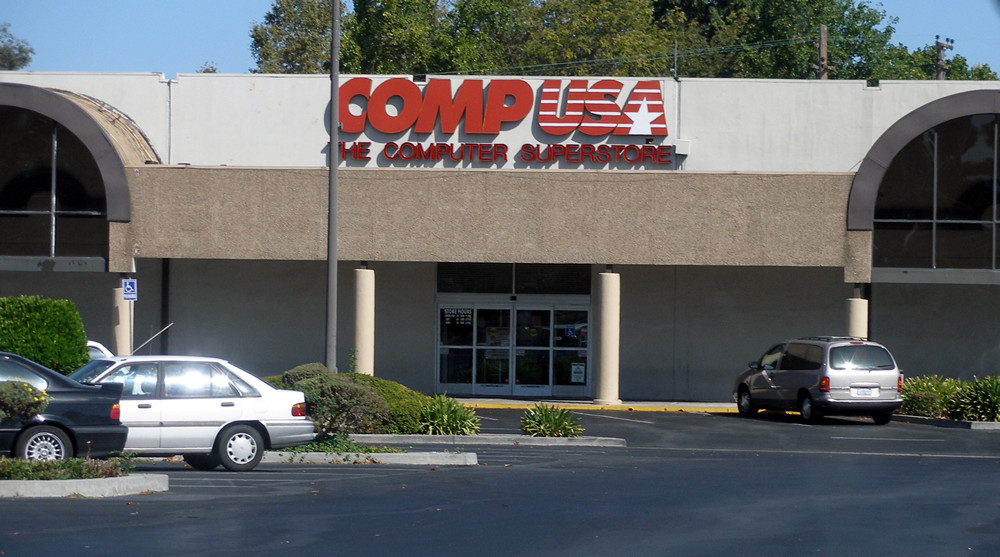 A CompUSA storefront in Santa Clara, California, with 'The Computer Superstore' signage over the entrance