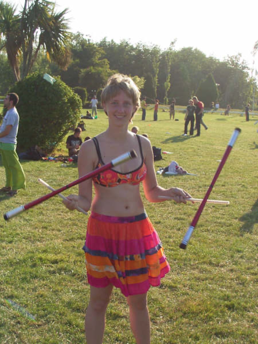 A juggler spinning a pair of devil sticks (flower sticks) outdoors at the European Juggling Convention in Ireland
