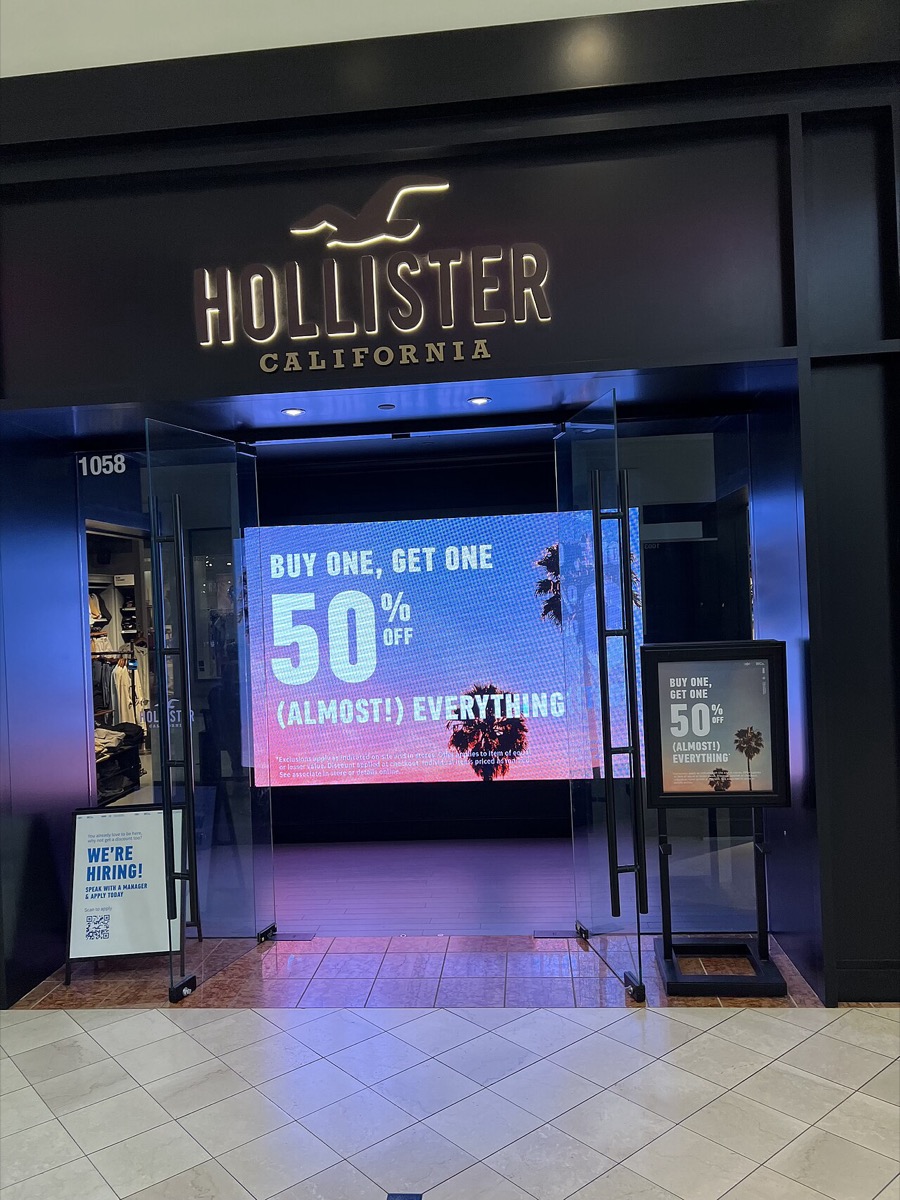 a Hollister Co. mall storefront — dark facade, glowing seagull logo