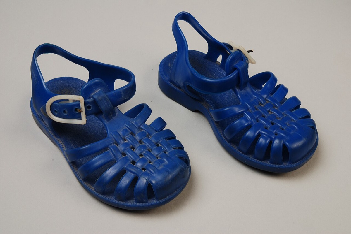 A pair of blue woven-style children's jelly sandals, photographed on a plain background