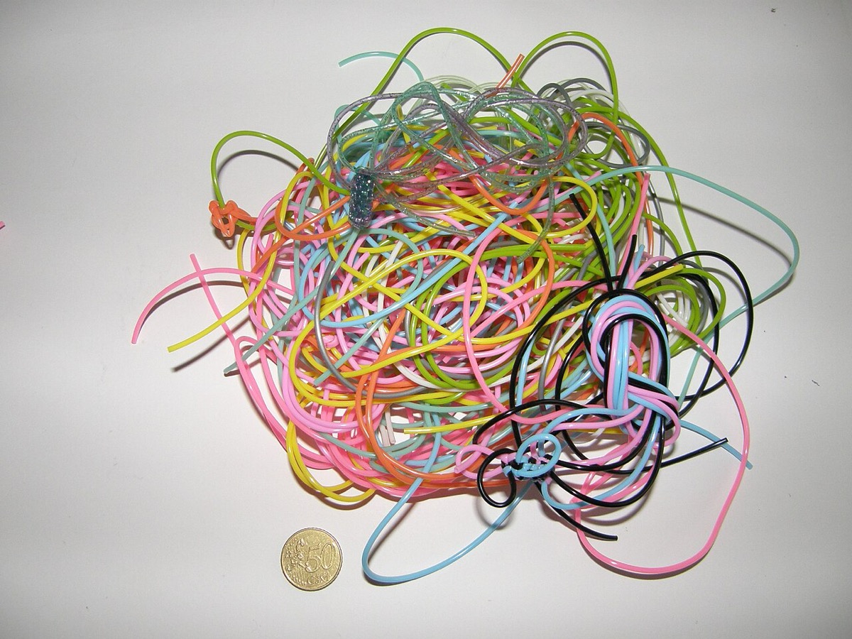 A tangle of brightly colored scoubidou / gimp plastic lacing, the material of the lanyard craft