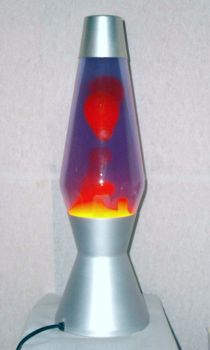 A glowing lava lamp with red wax rising through purple liquid on a silver base