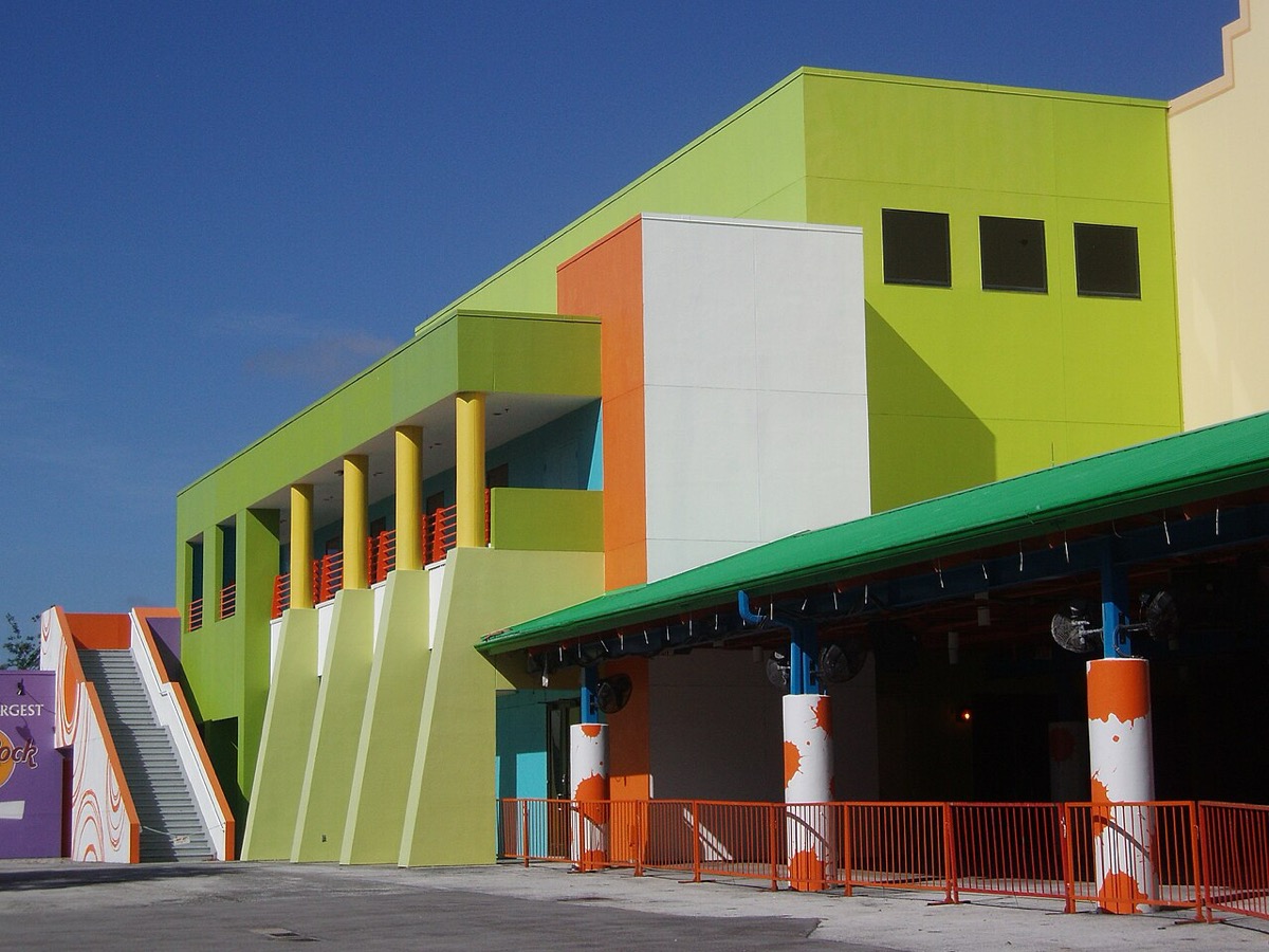 The brightly painted green, orange and yellow exterior of the Nickelodeon Studios building at Universal Studios Florida, with orange paint-splattered columns