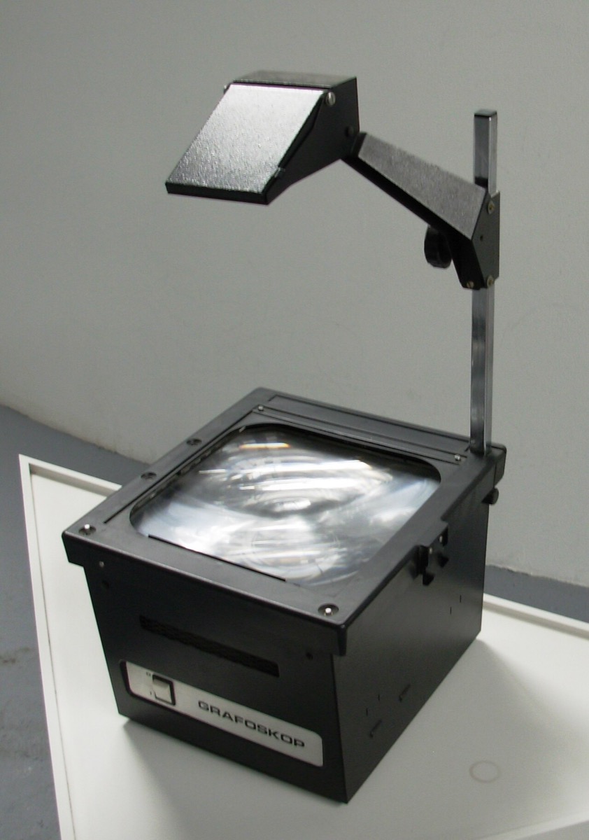 A classic overhead projector: black box with glass platen, upright post, and mirror head