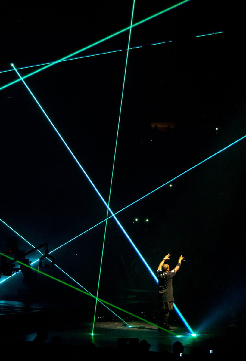 Criss-crossing teal and green laser beams against a dark background — the look of the classic picture-day laser backdrop