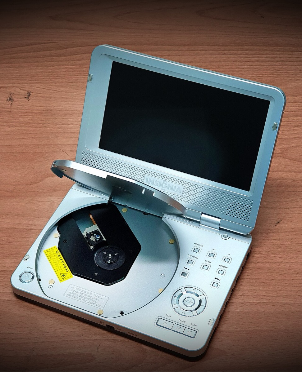 A silver Insignia portable DVD player, open with the screen up and the disc tray exposed