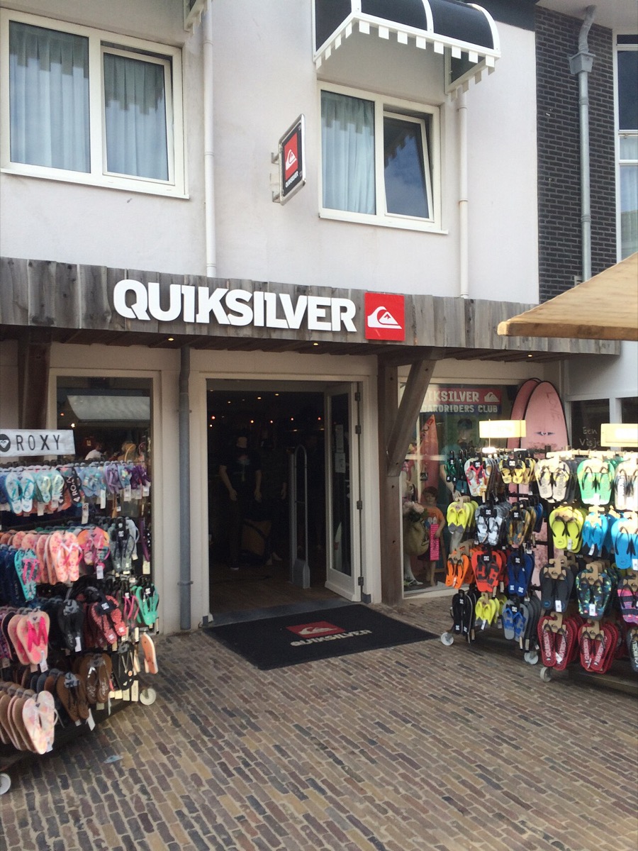 A Quiksilver shop entrance with the mountain-and-wave logo and wordmark over the door, a Roxy sign beside it