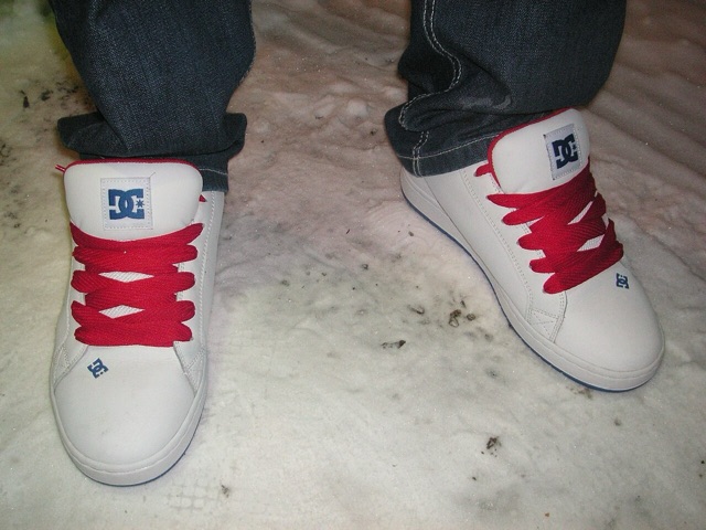 A pair of white DC skate shoes with fat red laces, photographed in 2010