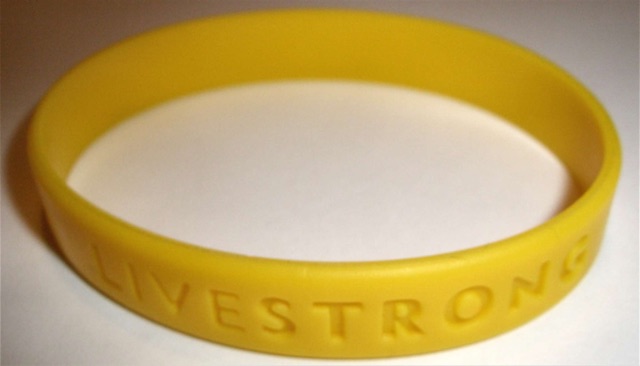A yellow silicone LIVESTRONG wristband on a plain background