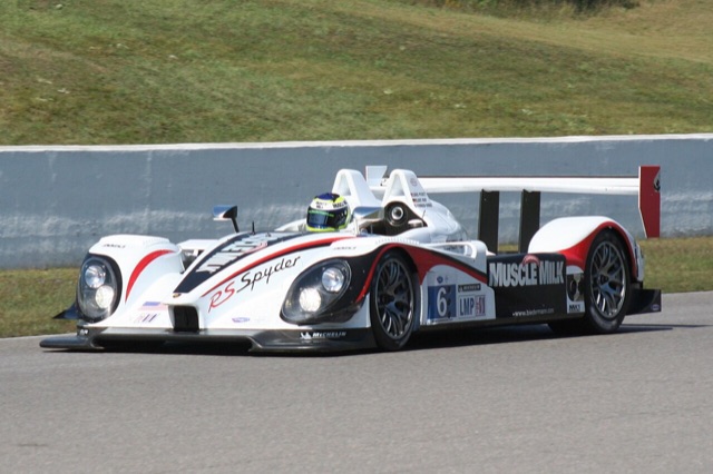 The Muscle Milk Team CytoSport Porsche RS Spyder race car — the brand's own prototype racing team — on track in its white, black, and red livery