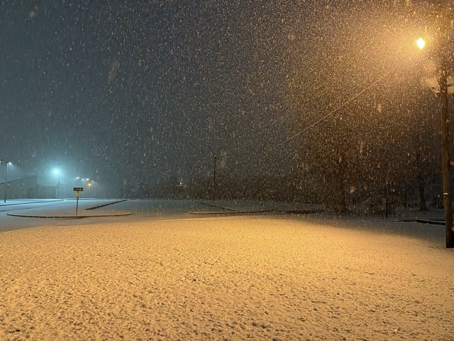 A sodium-vapor streetlight casting its orange glow over a snowy field at night in Westampton Township, New Jersey