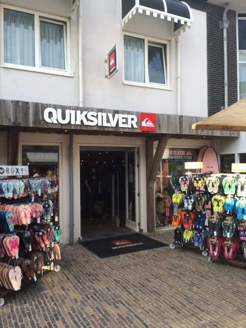 A Quiksilver shop entrance with the mountain-and-wave logo and wordmark over the door, a Roxy sign beside it