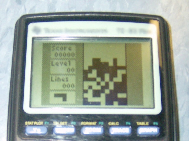 A TI-83 Plus graphing calculator running a Tetris-style falling-block game