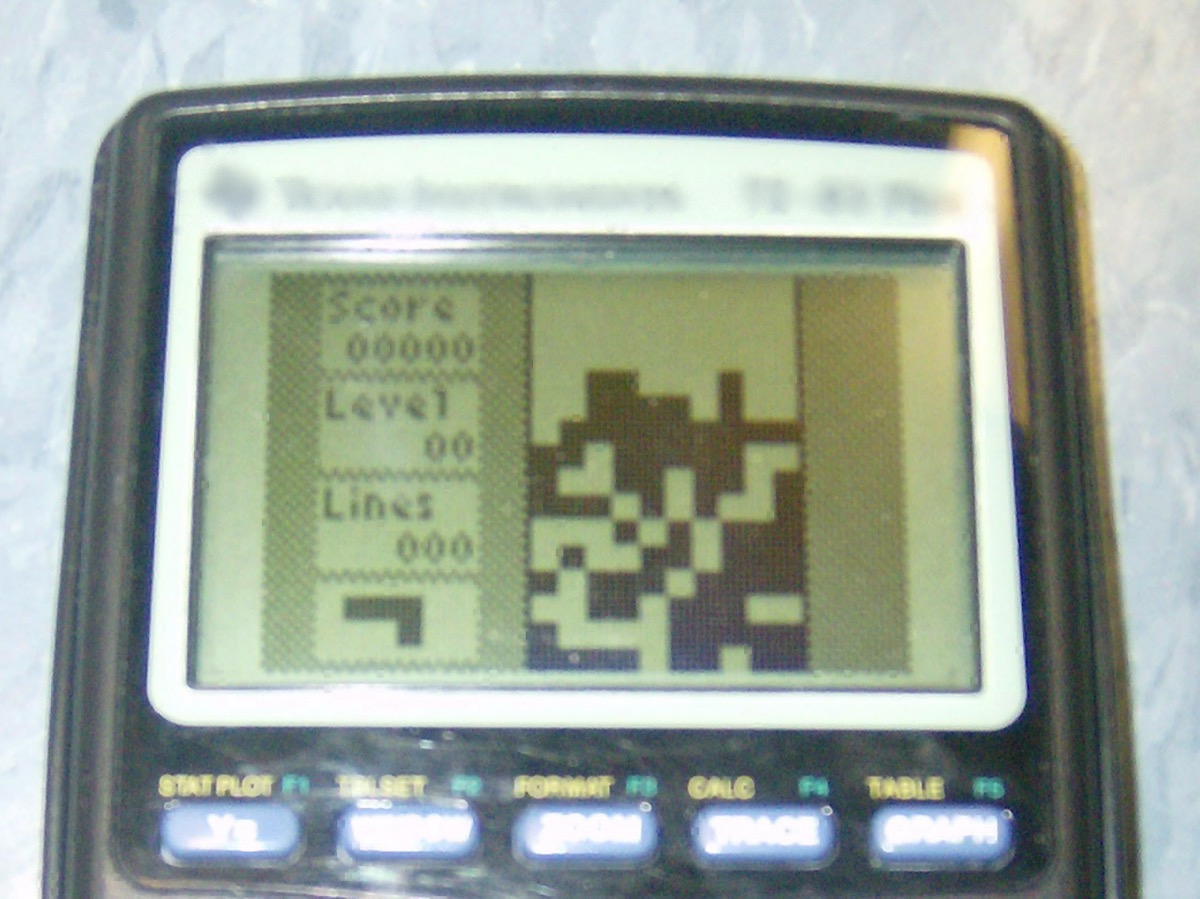A TI-83 Plus graphing calculator running a Tetris-style falling-block game